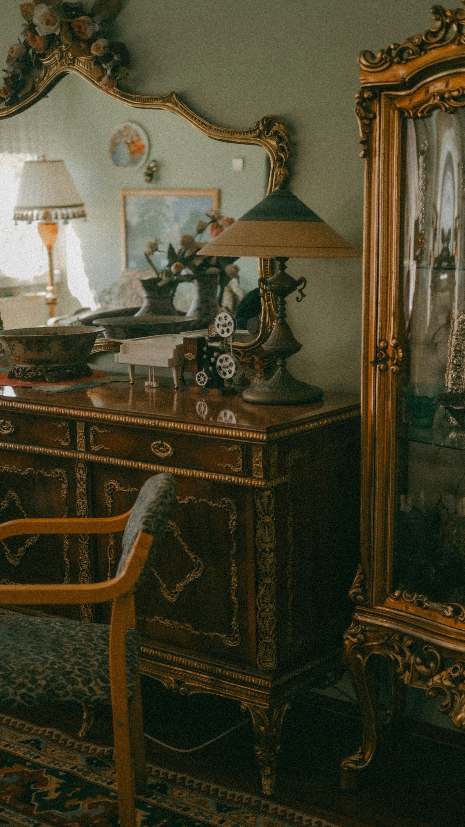 Interior de un apartamento parisino de la Belle Époque con cómoda dorada tallada, espejo antiguo, lámpara vintage y alfombra persa