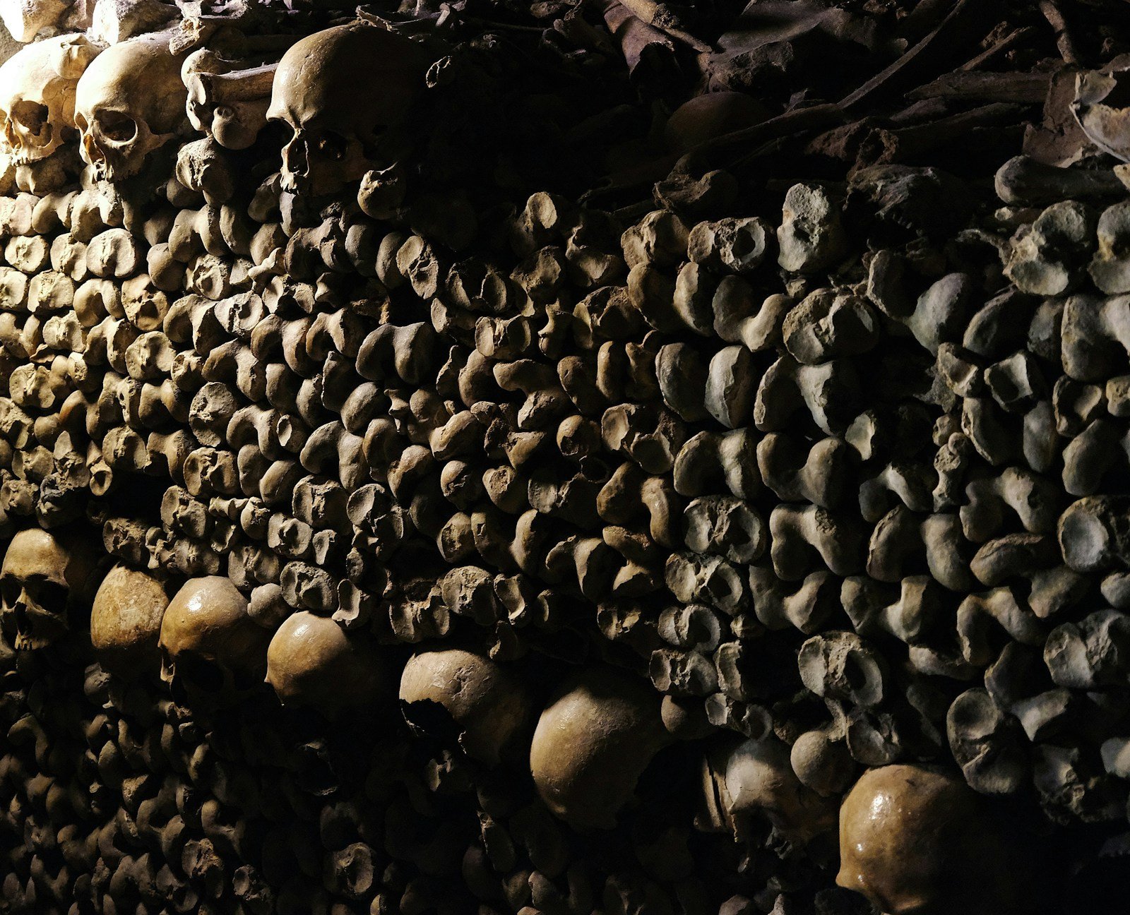 Calaveras y huesos apilados en los túneles subterráneos de las catacumbas de París